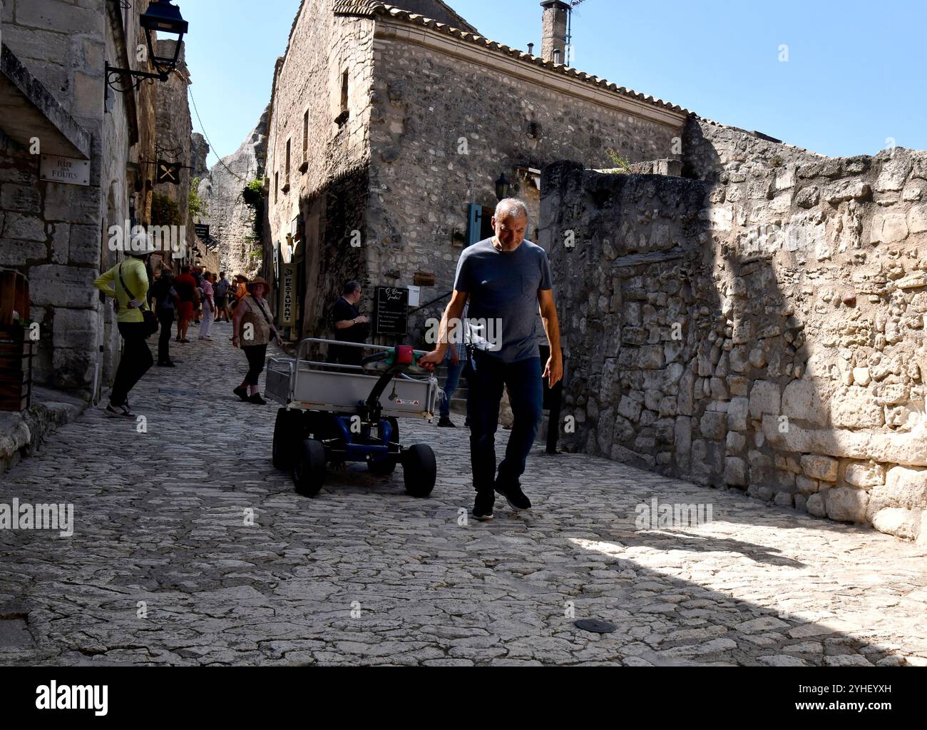 Delivering products with hand held cart on the narrow streets of Les Baux-de-Provence in the Bouches-du-Rhône department in the Provence-Alpes-Côte d' Stock Photo