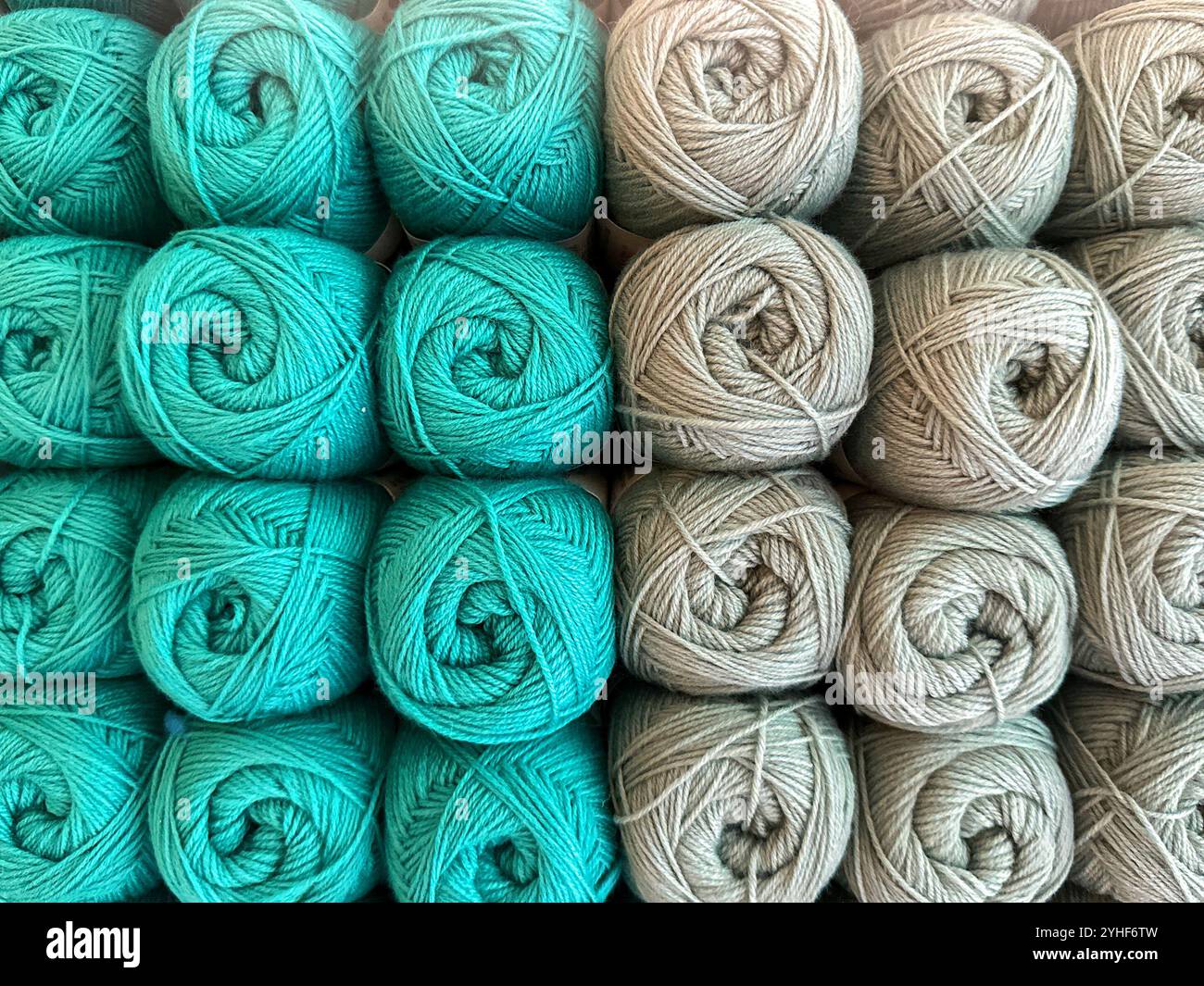 Close up view of balls of blue and beige wool on display in a knitting shop.. - Smartphone Captured Stock Image