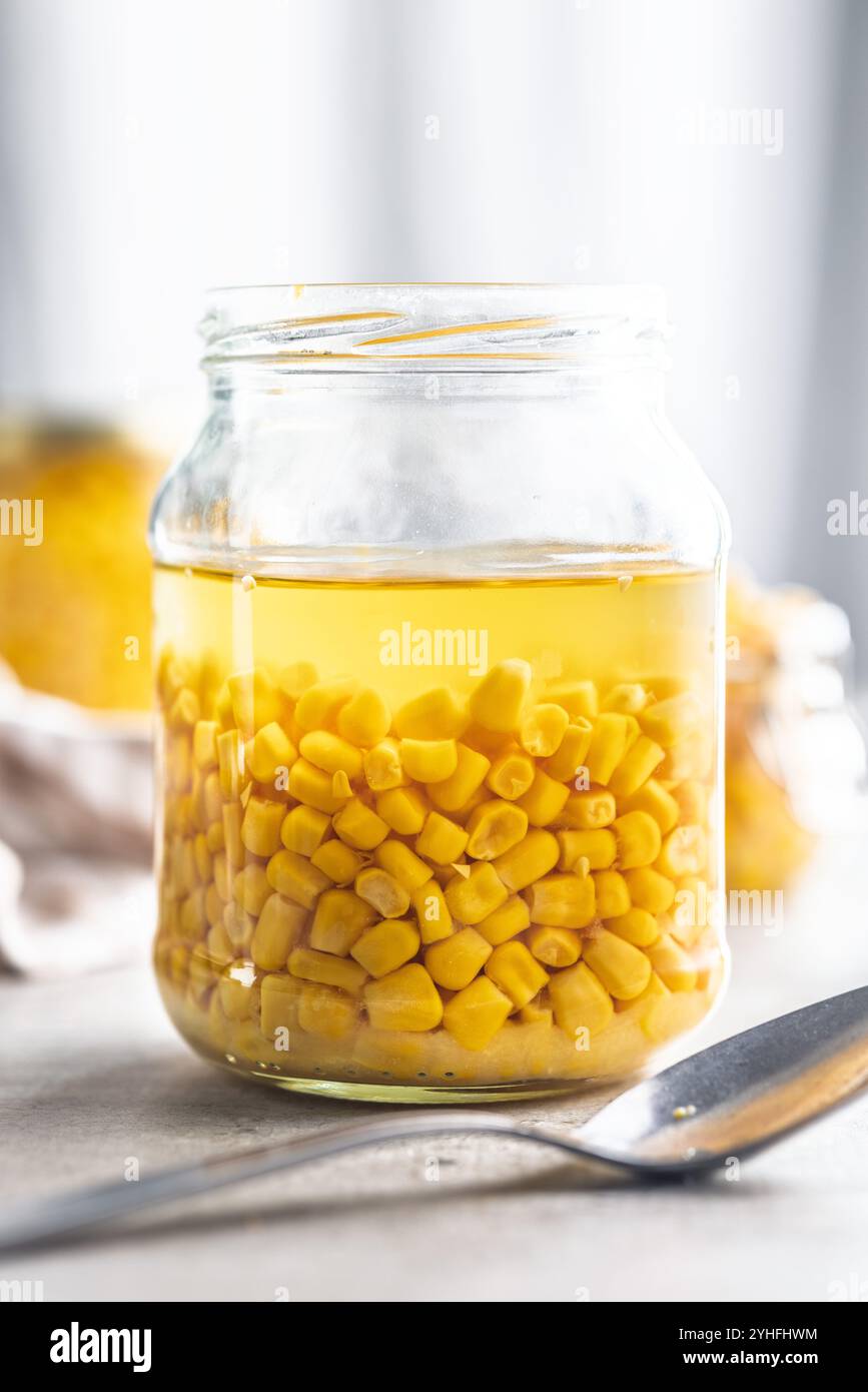 Canned sweet corn in jar on a kitchen table. Stock Photo