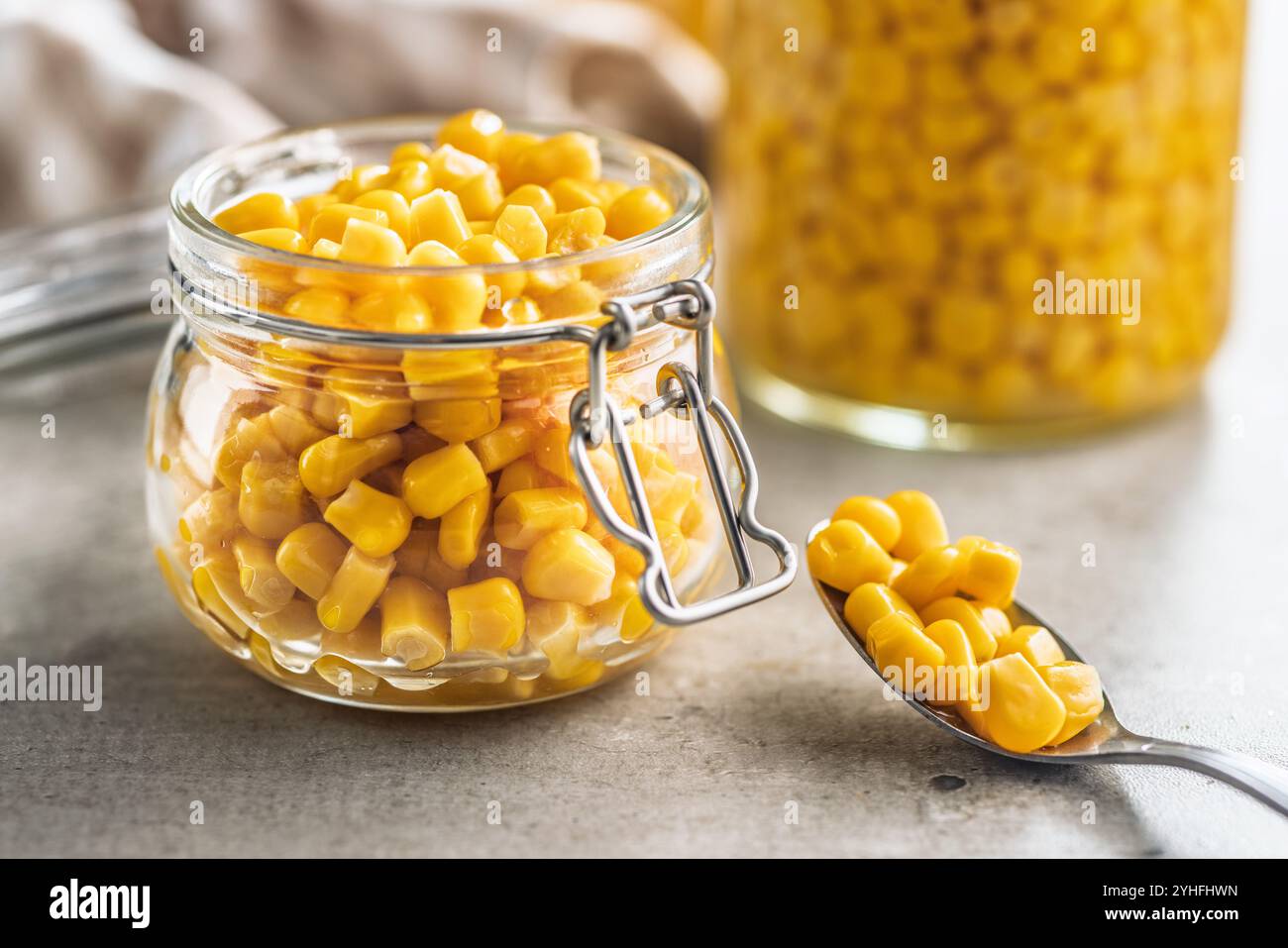 Canned sweet corn in jar on a kitchen table. Stock Photo