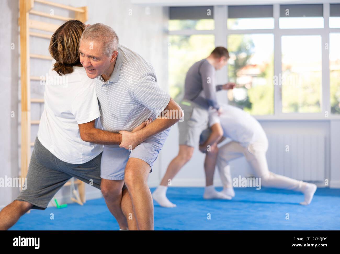 Man and senior man athletes in pair conduct training battle in oriental ...