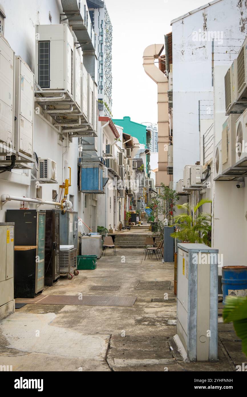 Alleyway between shophouses in Singapore with Air conditioner condenser units along the walls.The need for air conditioning is a carbon footprint challenge Stock Photo