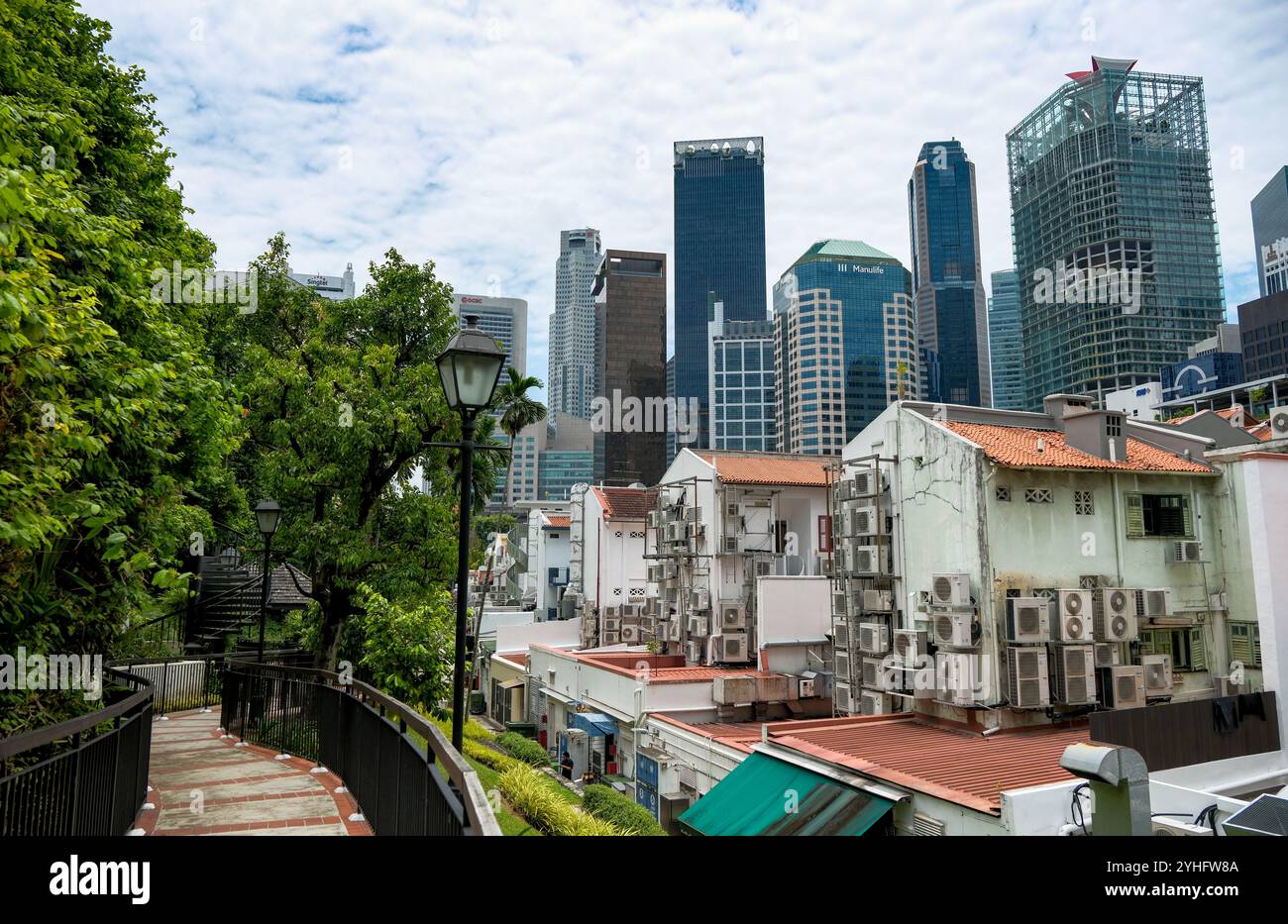 A view of the traditional Singapore Chinatown Shophouses in the foreground with the new city skyline of skyscrapers showing a mix of modern and old. Stock Photo