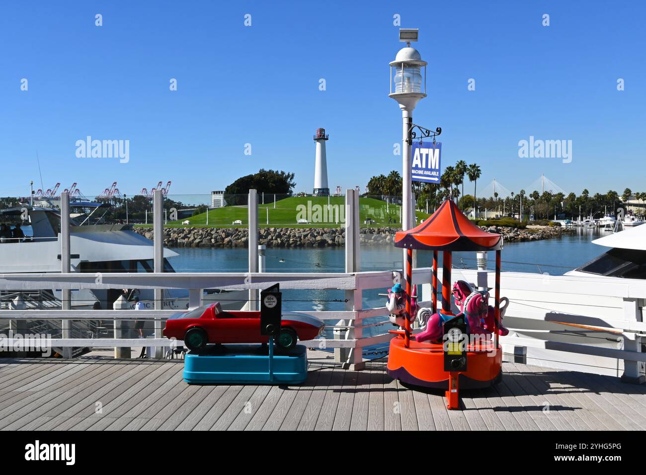 LONG BEACH, CALIFORNIA - 8 NOV 2024: Coin operated Kiddie Rides at Shoreline Village with the Lions Lighthouse in the background. Stock Photo