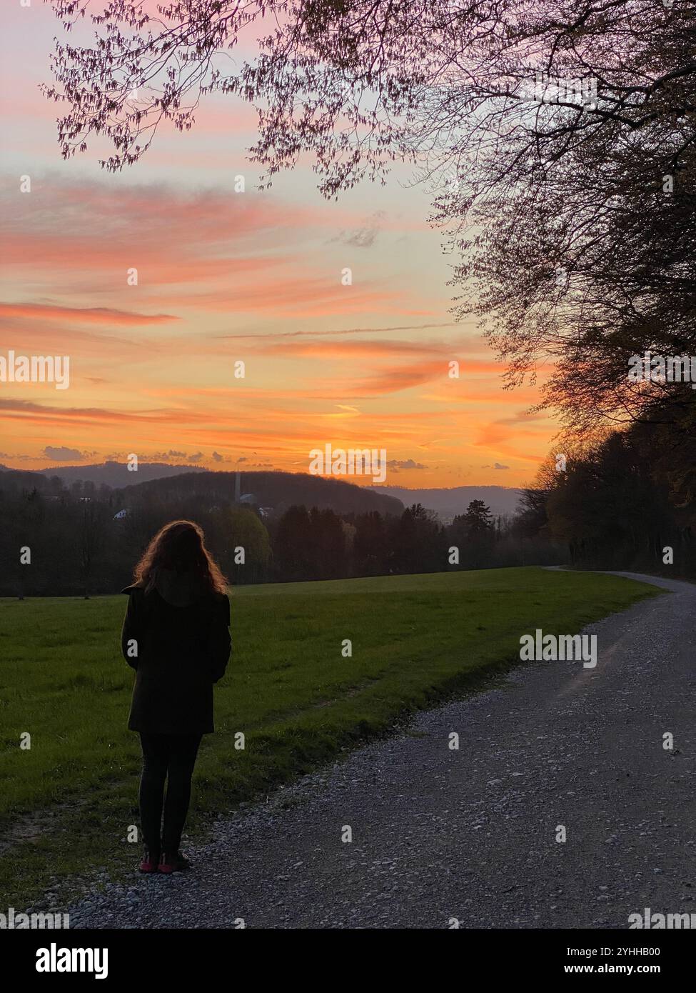 A young women watching sunset, Germany - Smartphone Captured Stock Image