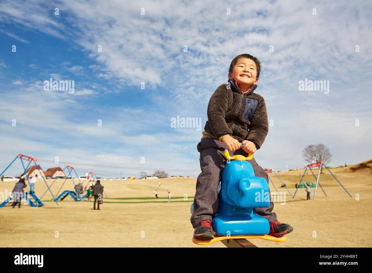 Boy playing on playground equipment Stock Photo