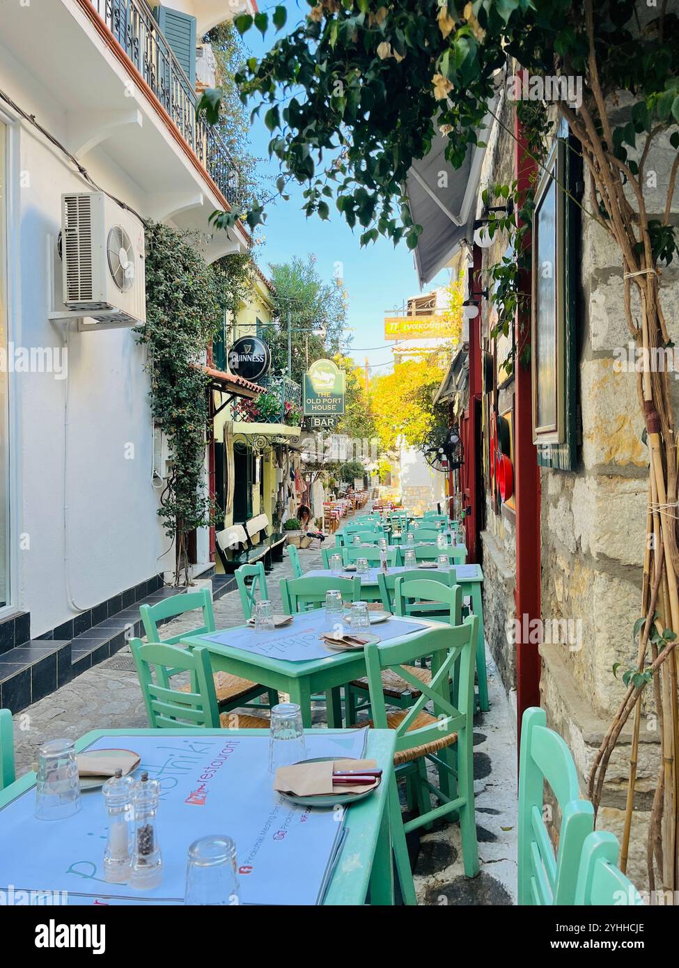 Greek/Mediterranean charm /outdoor tables, alleyway, greenery, and vibrant colours - Smartphone Captured Stock Image