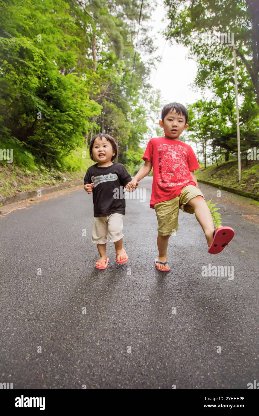 Brother and sister holding hands and walking Stock Photo - Alamy