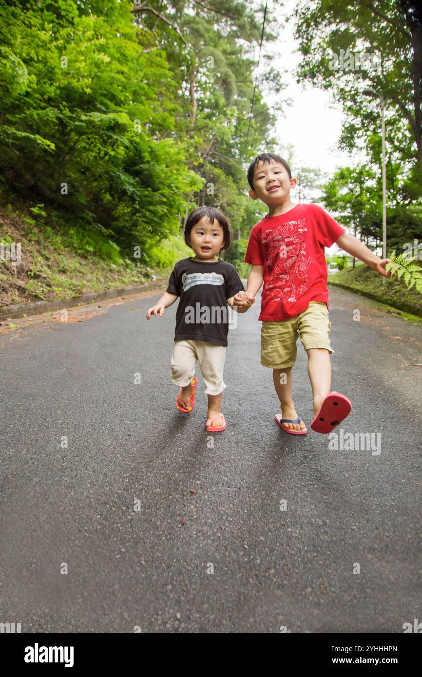 Brother and sister holding hands and walking Stock Photo - Alamy