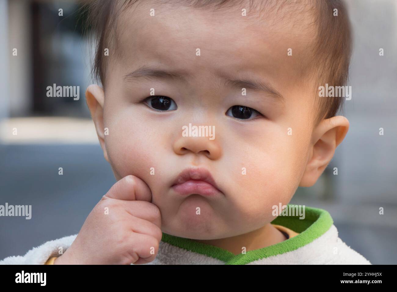 Toddler with hand on cheek Stock Photo