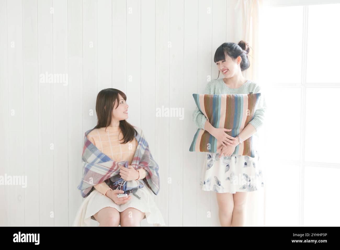 Two women in their 20s by the wall Stock Photo - Alamy