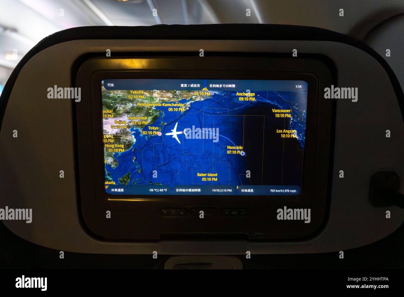 Flight tracking display shows airplane route over the Pacific Ocean with Asia and North America marked on the map Stock Photo