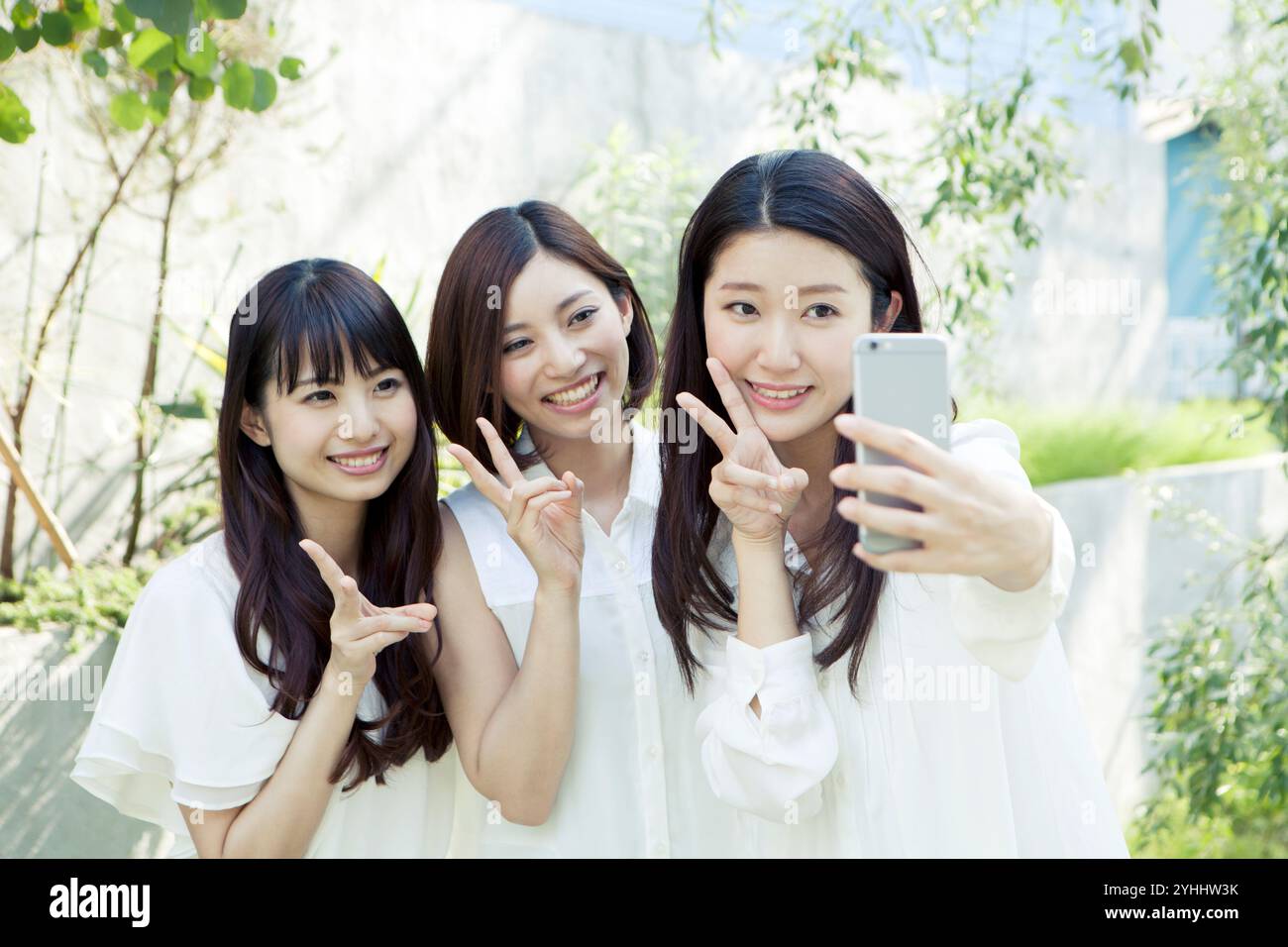 Three women with a phone hi-res stock photography and images - Alamy
