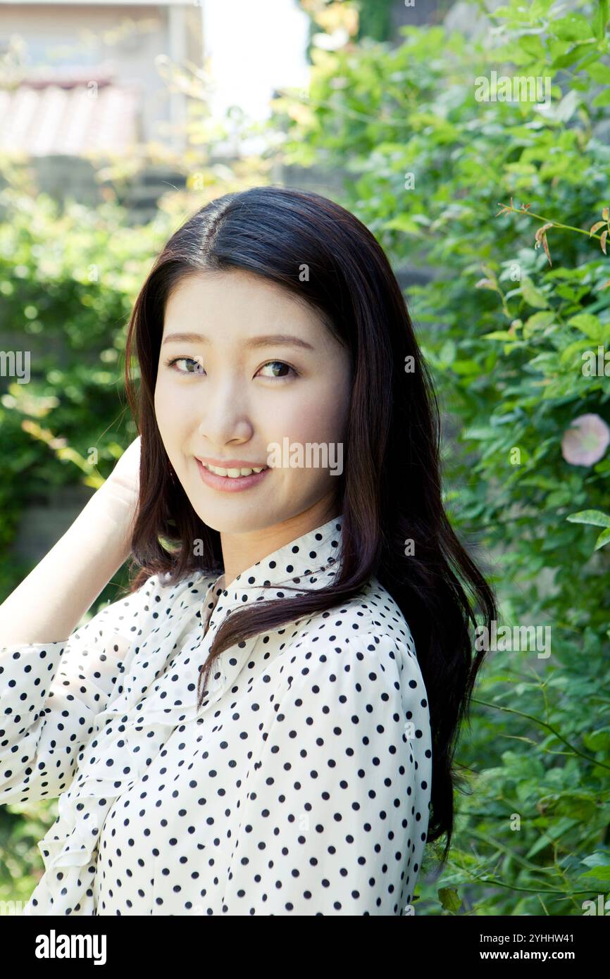 Woman in her 20s smiling in green Stock Photo - Alamy