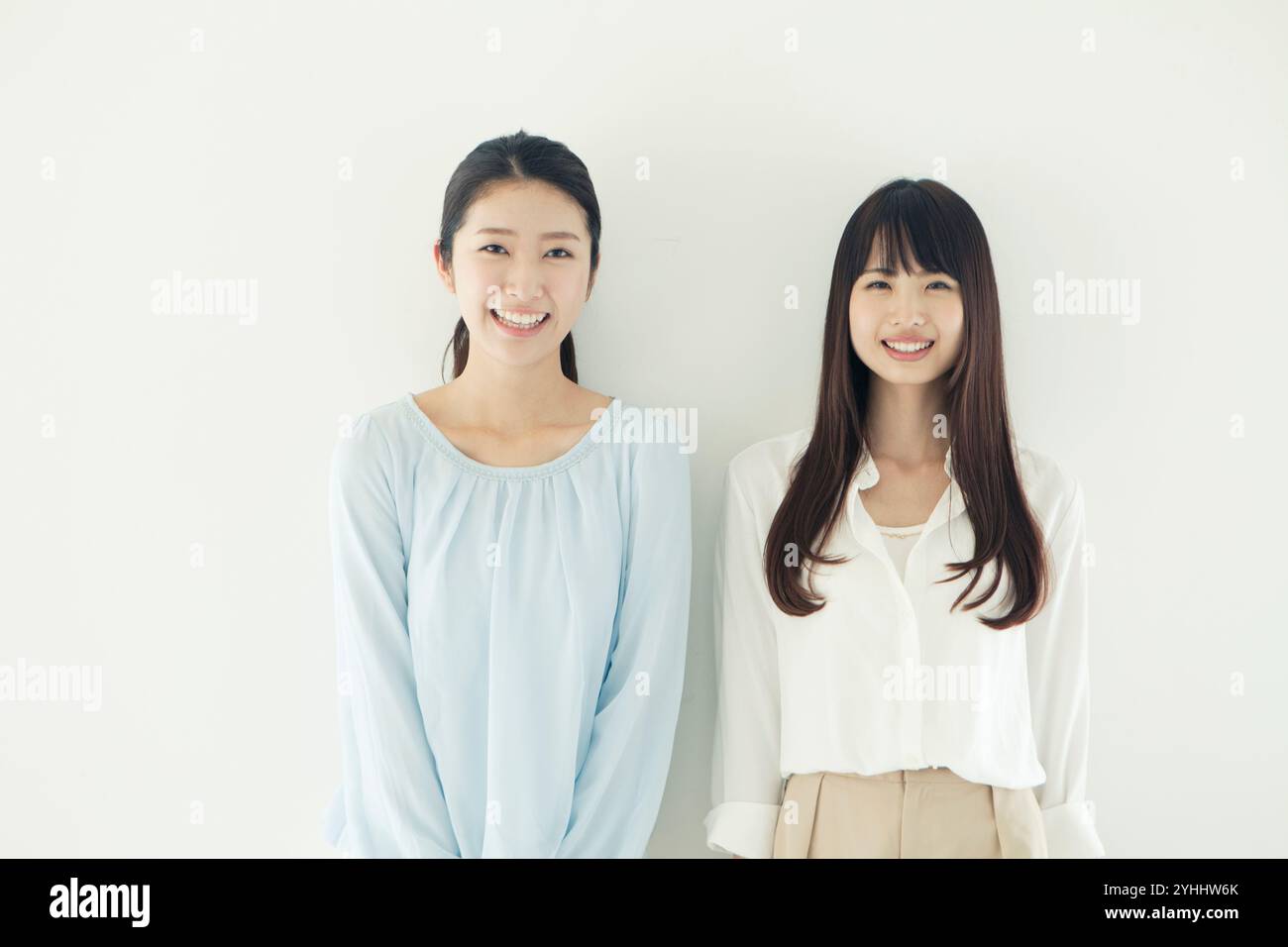 Two women in their 20s smiling in a friendly row Stock Photo - Alamy