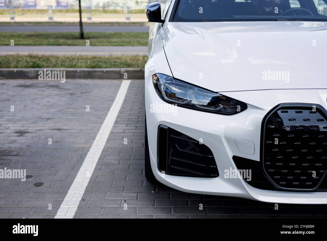 Minsk, Belarus, November 12, 2024 - Luxury BMW i4 M50 on a parking lot. View on headlight and front grille of modern car. Stock Photo