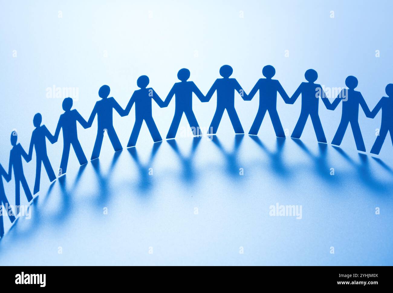 Paper people standing together hand in hand Stock Photo