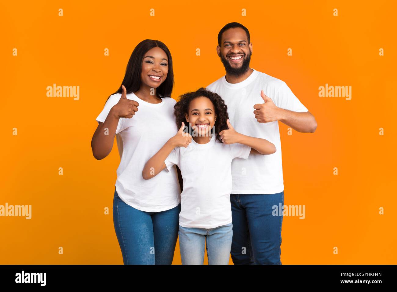 Happy black family gesturing thumbs up and smiling Stock Photo - Alamy