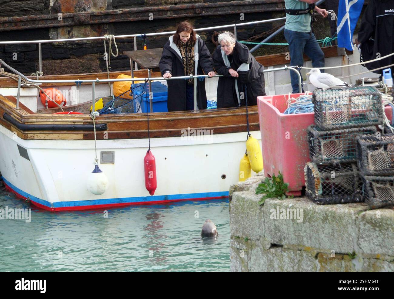 Emma Thompson and Ruth Watson are entertained by a wild seal whilst relaxing after filming a sequence for the New Apple TV thriller series “Down Century Road”. Starring and executive produced by Academy Award, BAFTA, Golden Globe and Emmy Award winner Emma Thompson (“Good Luck to You, Leo Grande,” “Sense and Sensibility”) who plays struggling Oxford private eye Zoë Boehm, alongside Golden Globe and two-time Olivier Award winner Ruth Wilson (“Luther,” “The Affair,” “His Dark Materials”) as Sarah Tucker, who becomes obsessed with the whereabouts of a child she believes to have gone missing. Stock Photo