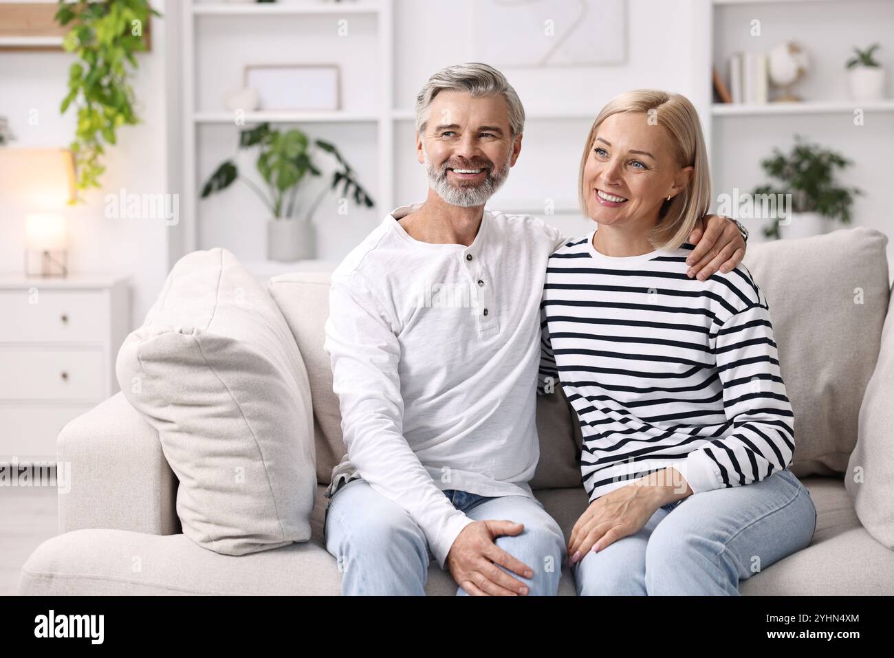 Happy middle aged couple on sofa at home Stock Photo - Alamy