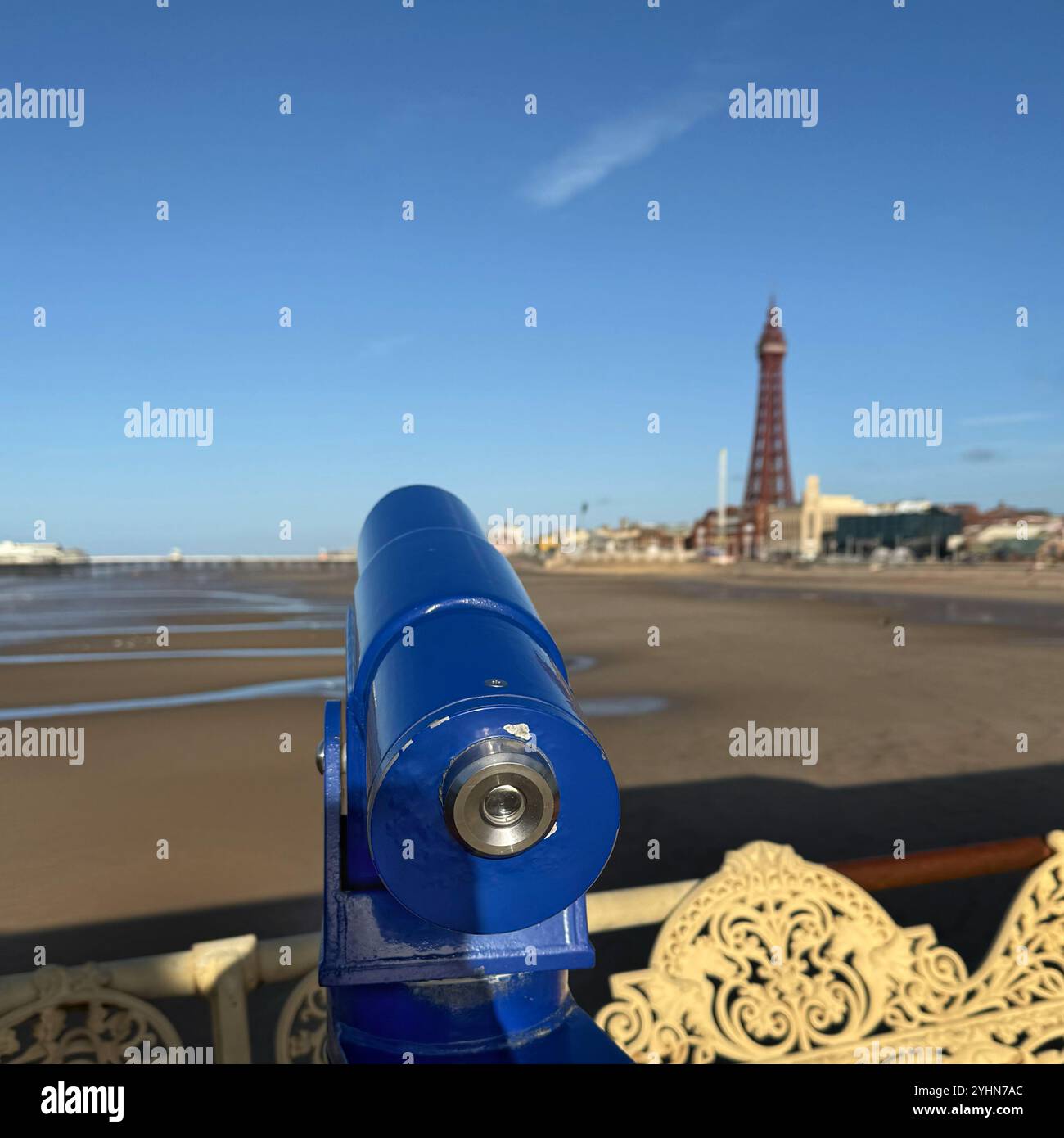 Blue telescope on Central Pier Looking over beach at low tide towards North Pier and Blackpool Tower, Blackpool UK - Smartphone Captured Stock Image