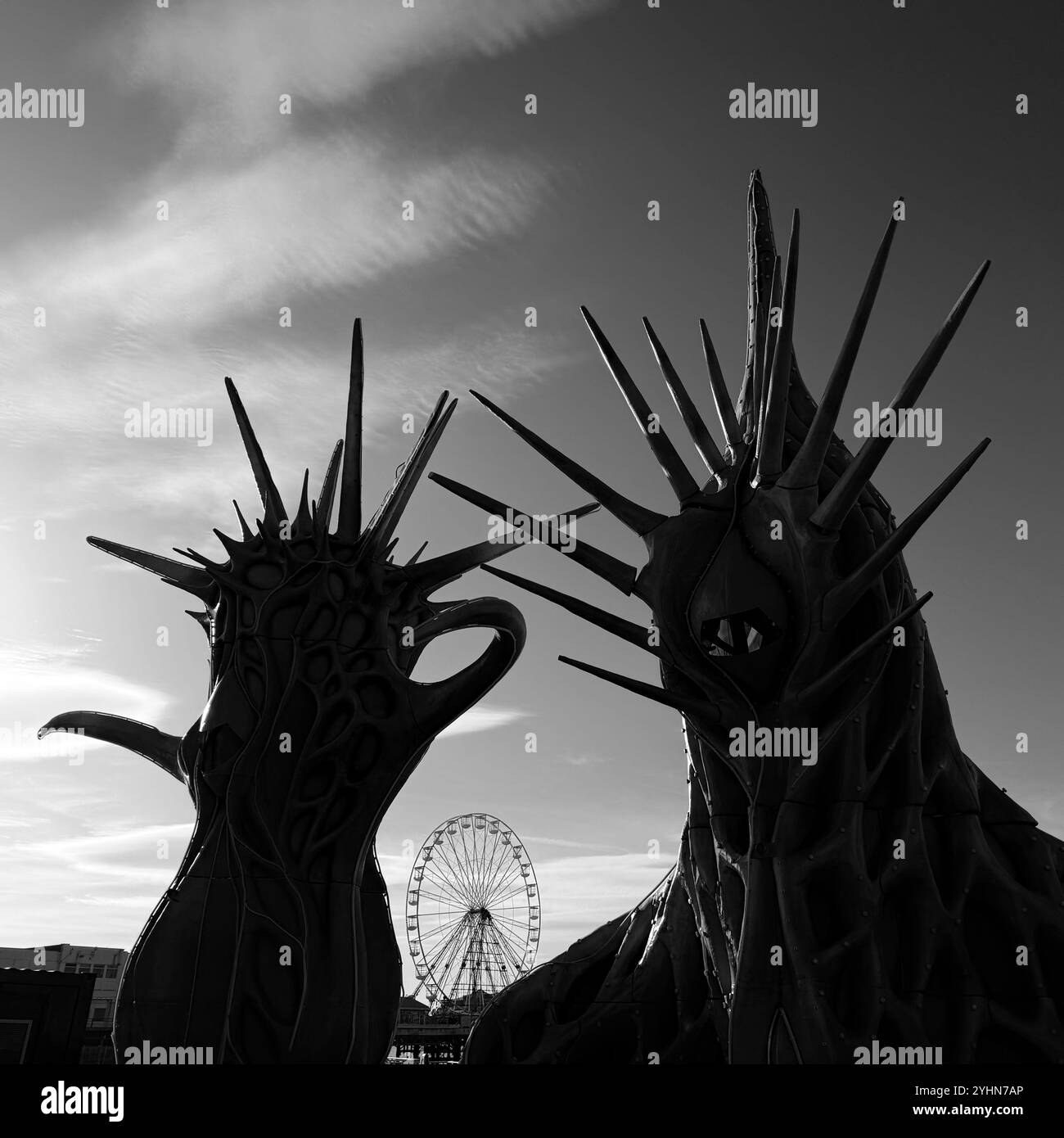 Backlit fibreglass structures in silhouette (odyssey sculpture)  Blackpool promenade with Big wheel on Central Pier in distance, Blackpool UK - Smartphone Captured Stock Image