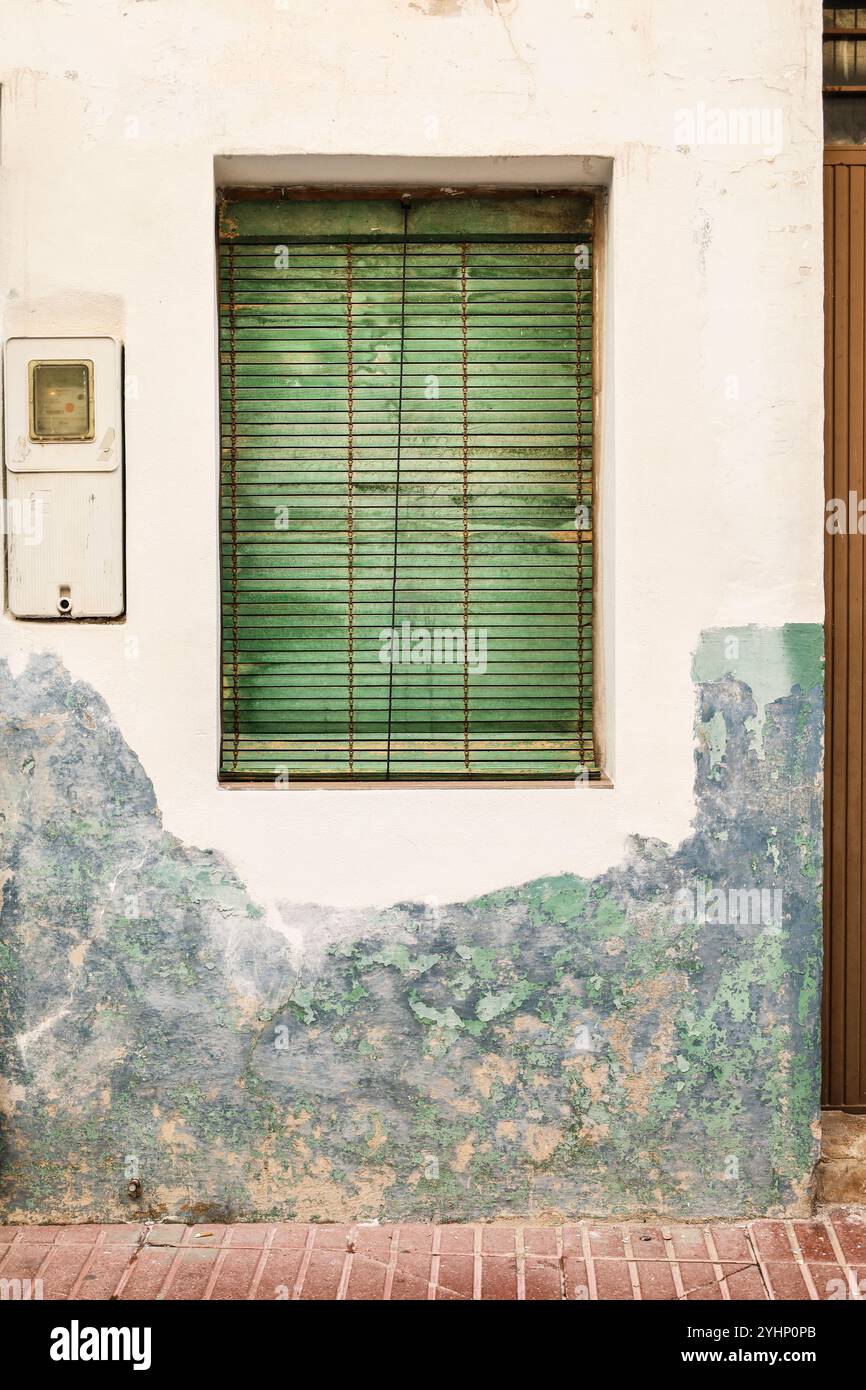 Old chipped facade with window and green blind in Spain Stock Photo - Alamy