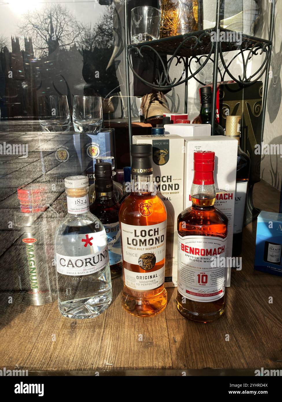 Caorunn Gin ,Loch Lomond Single Malt Whisky and Benromach Single Malt Whisky for sale in an Edinburgh shop  window - Smartphone Captured Stock Image