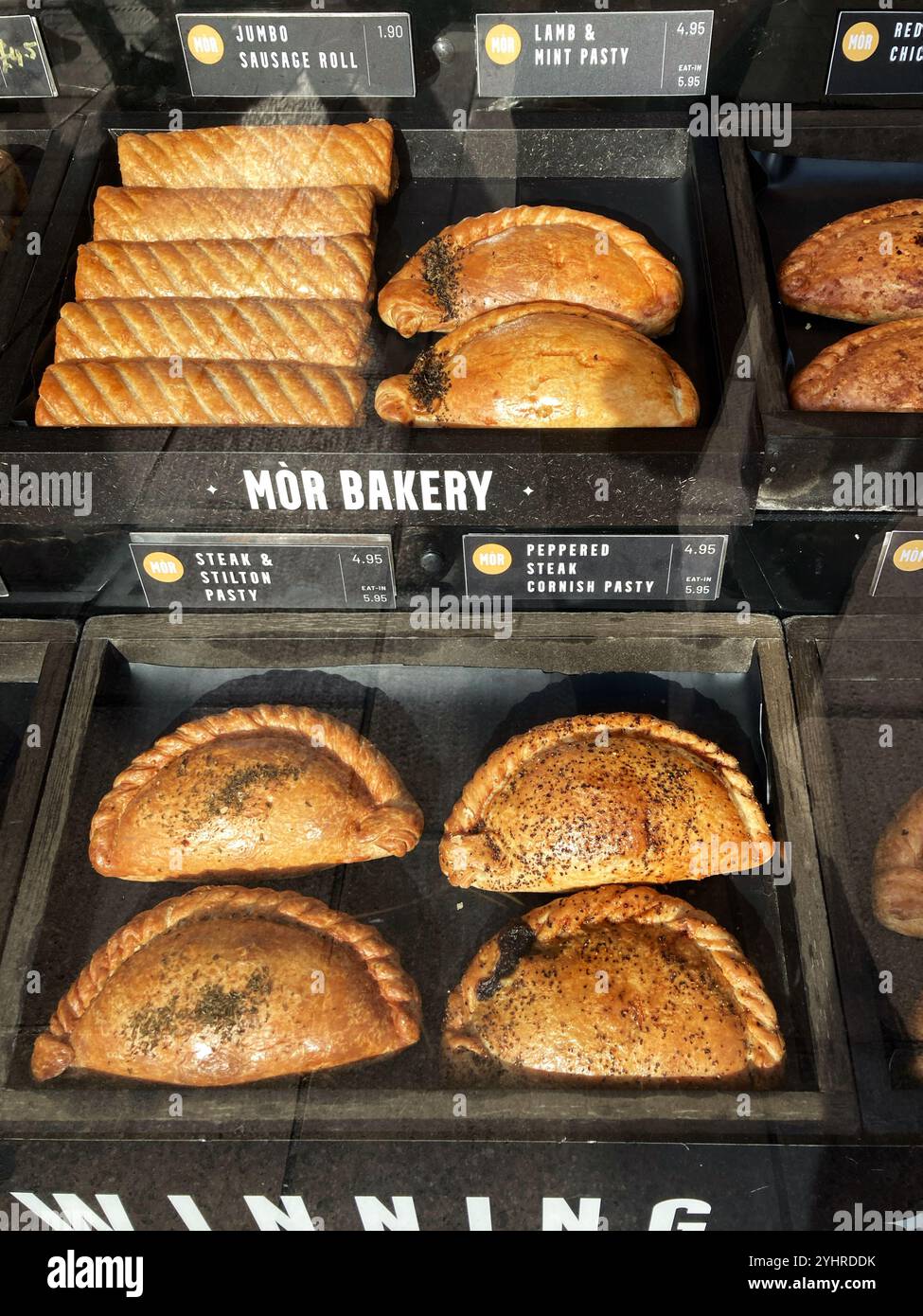 Savoury Sausage Rolls, Lamb & Mint pasty, Steak & Stilton Pasty and Peppered Steak Cornish Pasty, for sale in delicatessen shop window - Smartphone Captured Stock Image