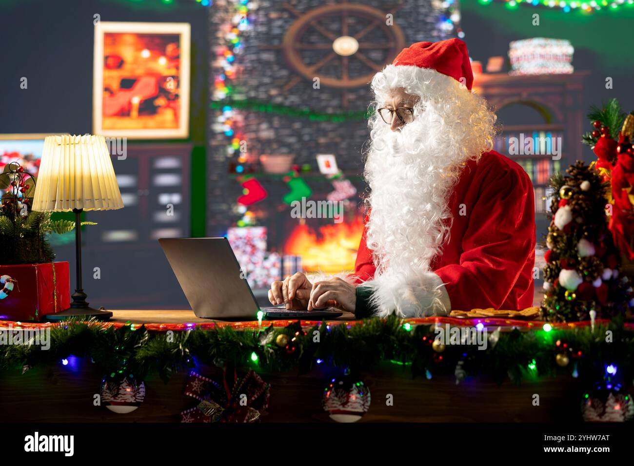 Santa Claus in his red suit browses webpages in his North Pole workshop ...