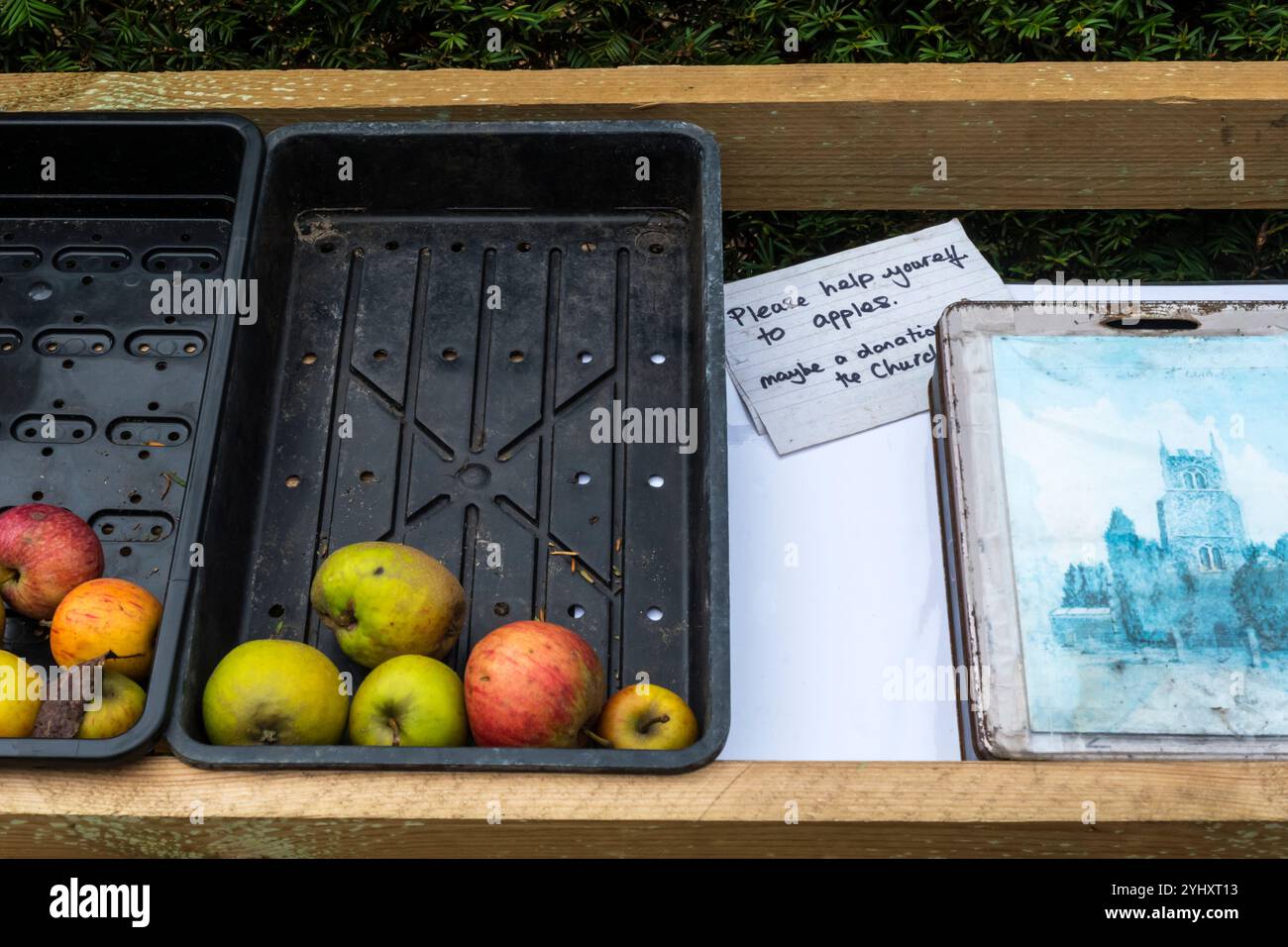 Sign offers free apples and suggests paying a donation to the church. Stock Photo
