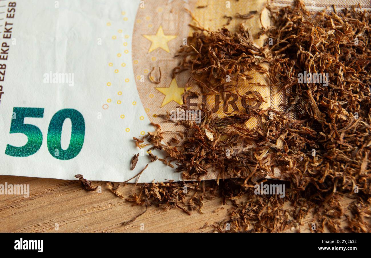 tobacco as currency Conceptual photo of tobacco on Euro currency, highlighting the economic  cost of tobacco products Stock Photo