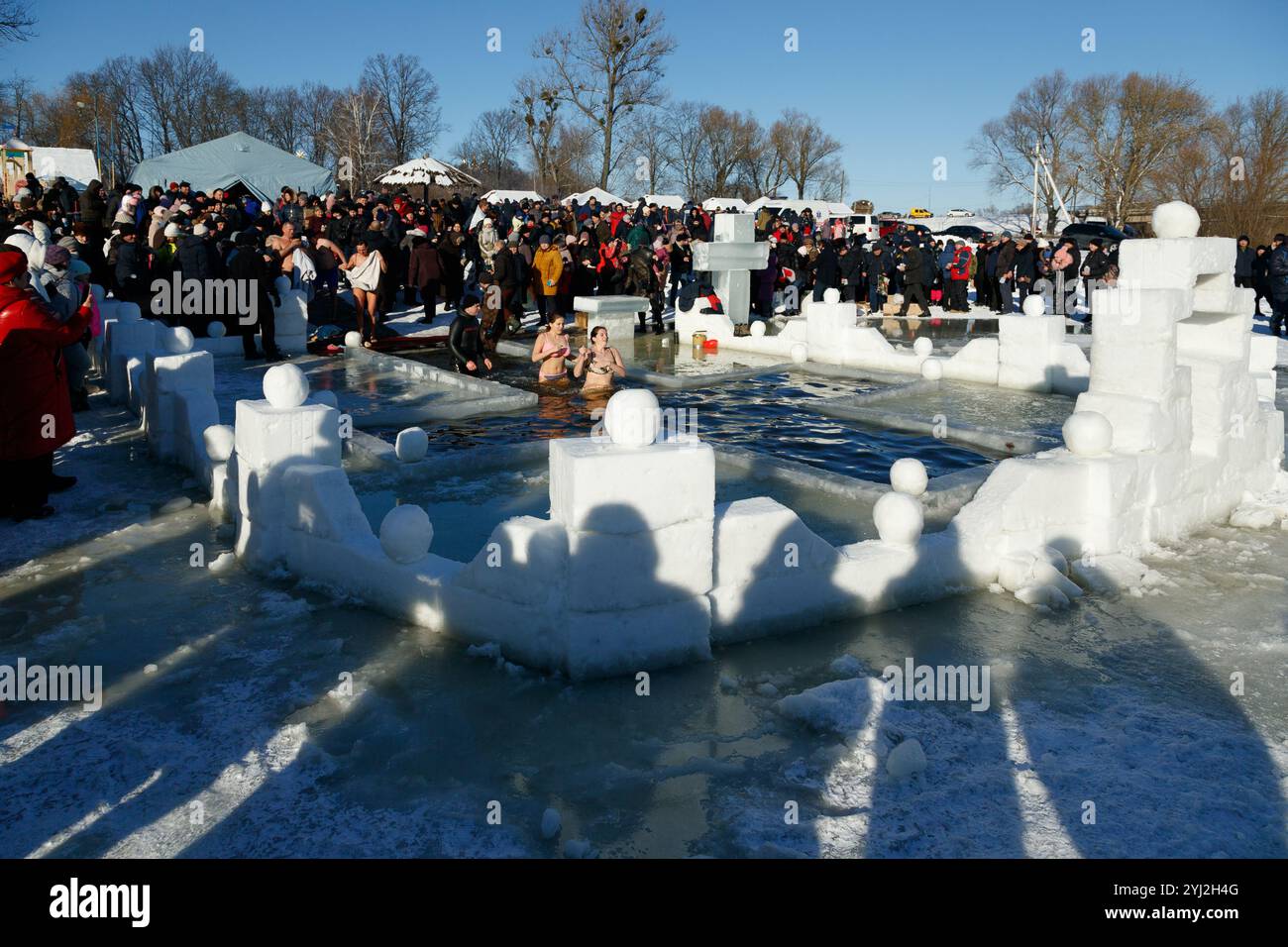 Ukraine, the city of Romny, January 19, 2022: the feast of the Baptism of the Lord. Orthodox rite of bathing in the ice hole. Epiphany. Many people co Stock Photo