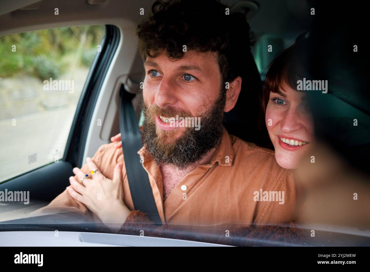 Smiling man and woman enjoying a car ride together. Stock Photo