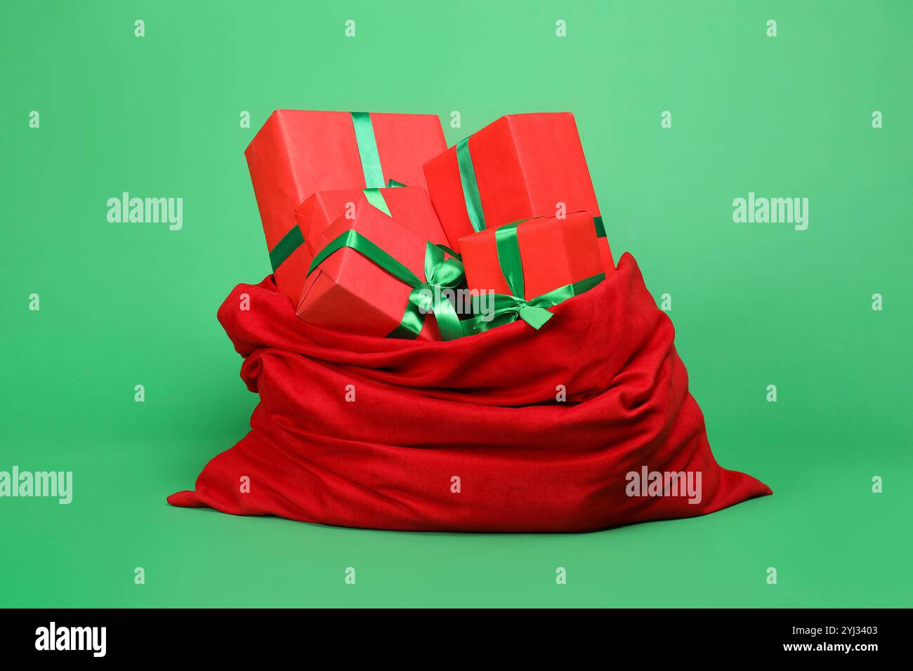 Red Santa Claus bag with gift boxes on green background Stock Photo - Alamy