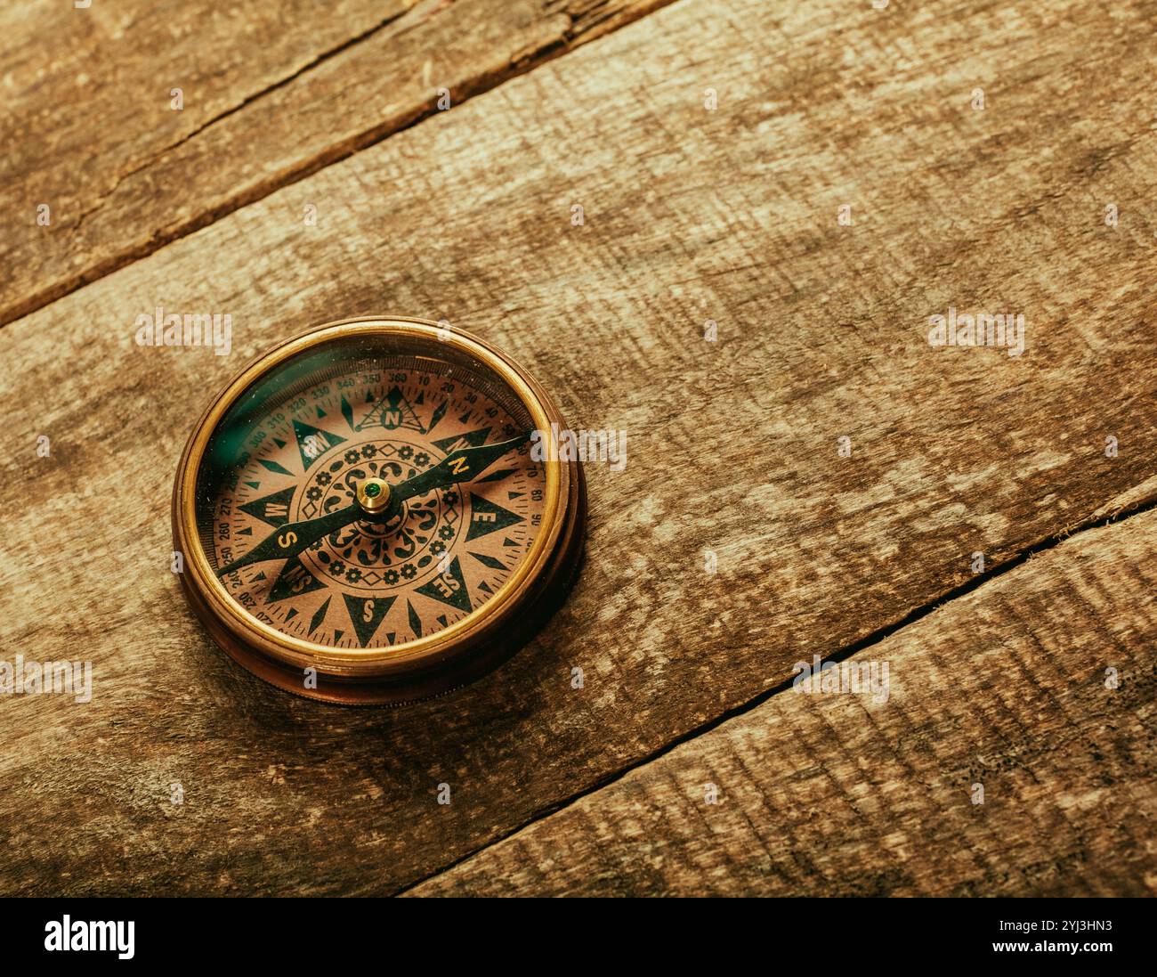 old-fashioned compass on rustic wooden table Stock Photo