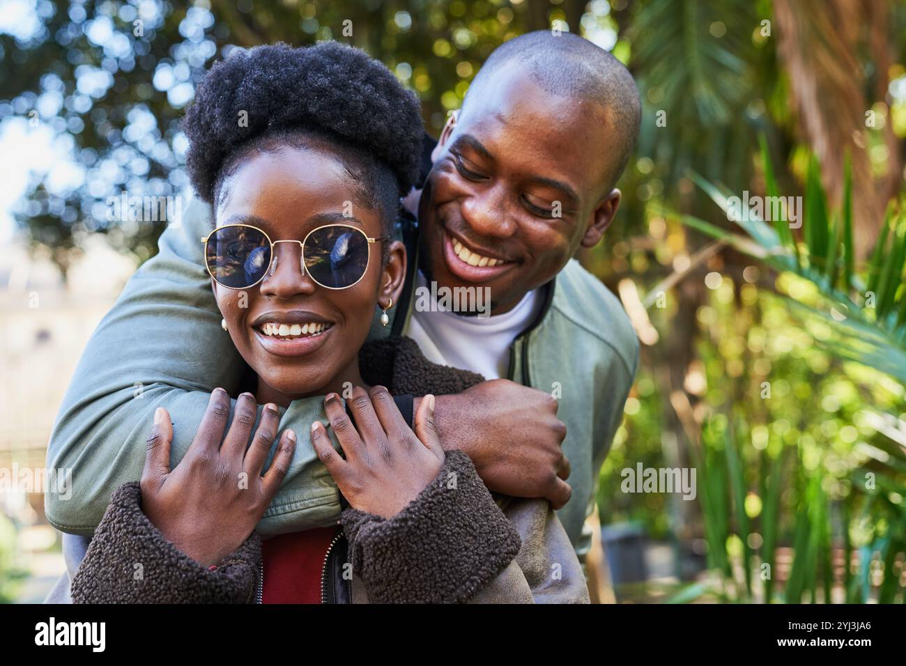 Joyful Couple Embracing Outdoors in a Green Urban Setting, Sharing ...