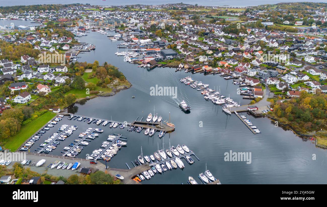 Aerial view of coastal town with a marina filled with boats, surrounded ...