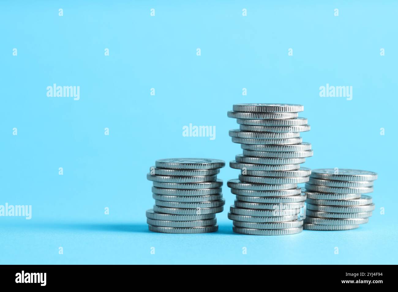 Salary concept. Stacked coins on light blue background, space for text ...