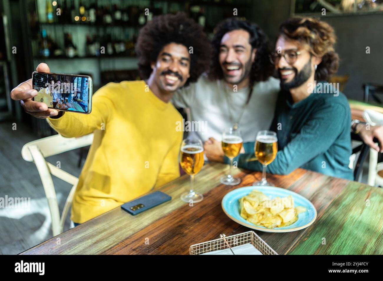 Happy friends taking selfie and drinking beer at the bar Stock Photo