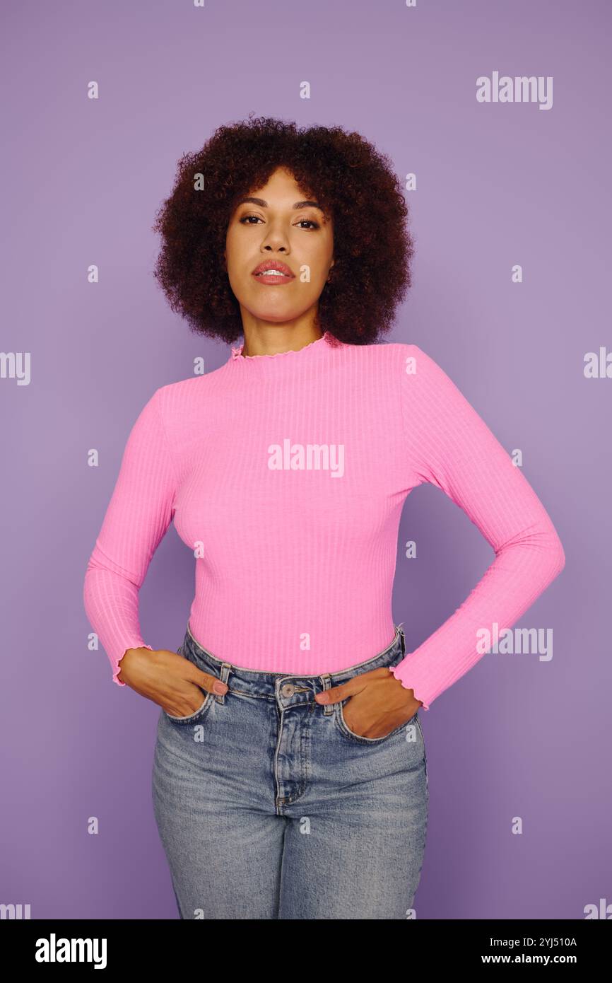 A young African American woman with curly hair confidently standing in ...