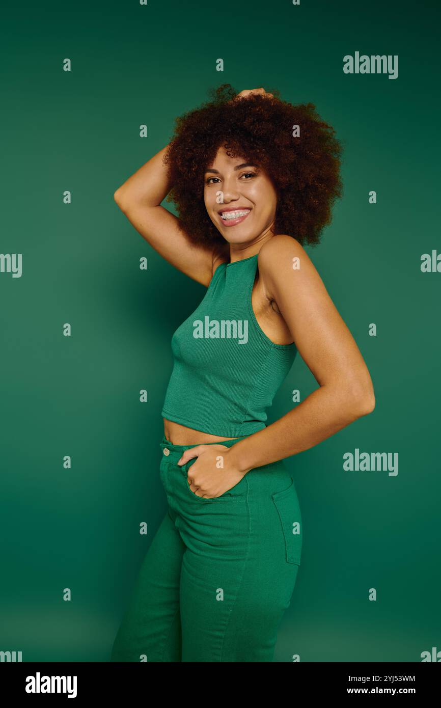A cheerful young woman with curly hair enjoys a playful moment in ...