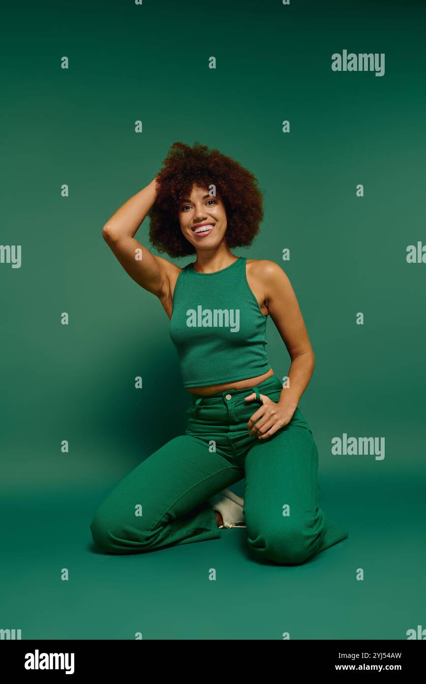 A stylish young woman with curly hair expresses joy, posing casually in ...