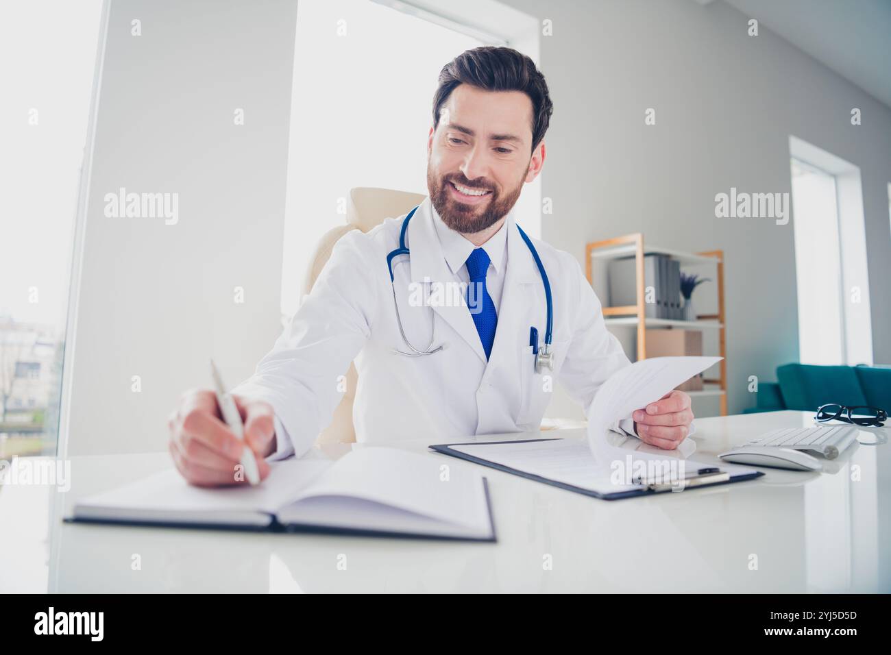 Photo of experienced doctor guy sit table hold paper check list write ...