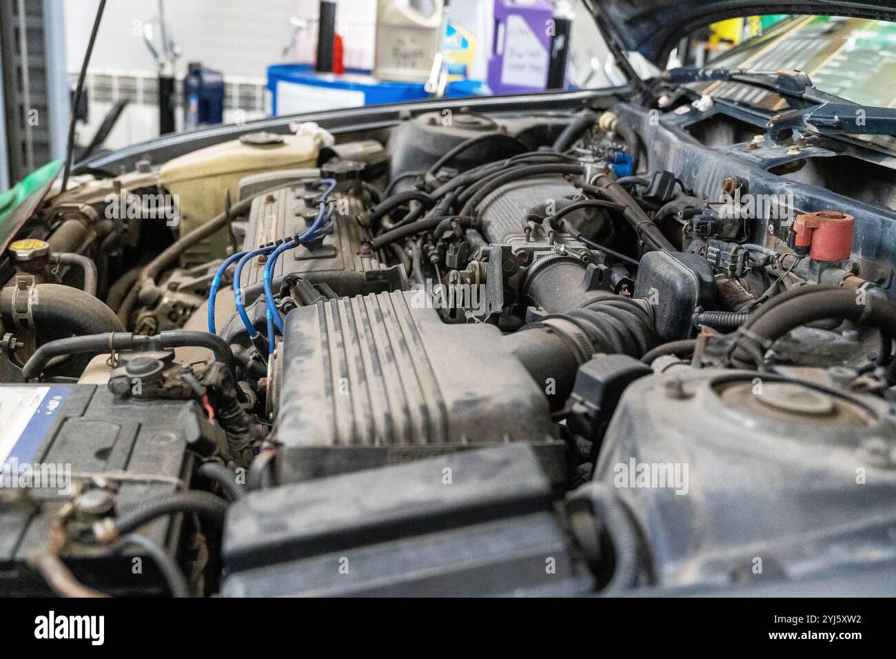Engine components and wiring in a vehicle being serviced at a garage ...
