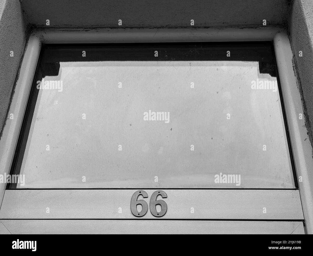 Number 66 on Glass Door Frame, Isolated in Negative Space with Sky Reflection Stock Photo