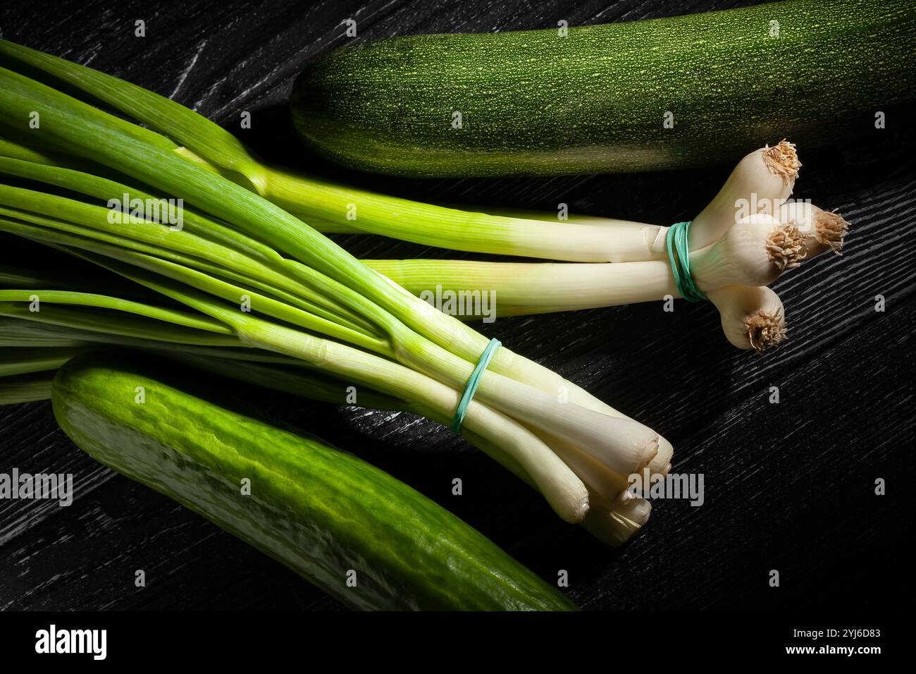 young garlic scallion on black wood background Stock Photo
