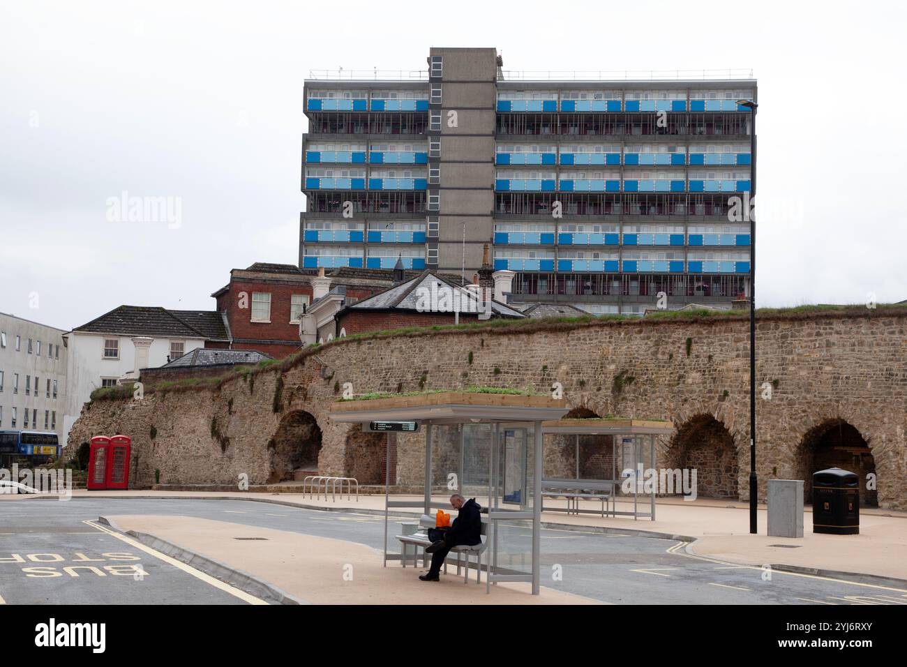 A person waits at a bus stop in Southampton Stock Photo