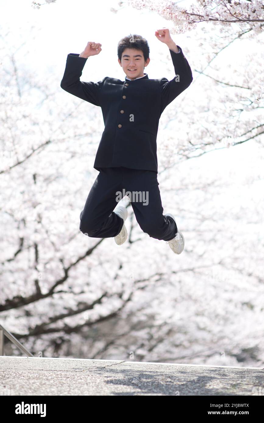 Junior high school boys and girls jumping with cherry blossoms Stock ...