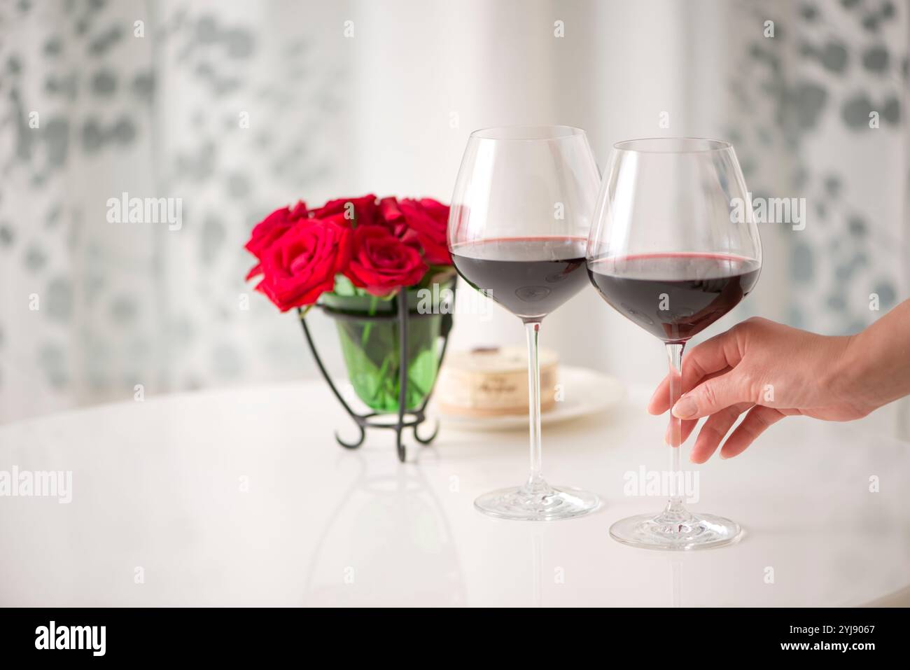 Woman's hand holding a glass of red wine Stock Photo